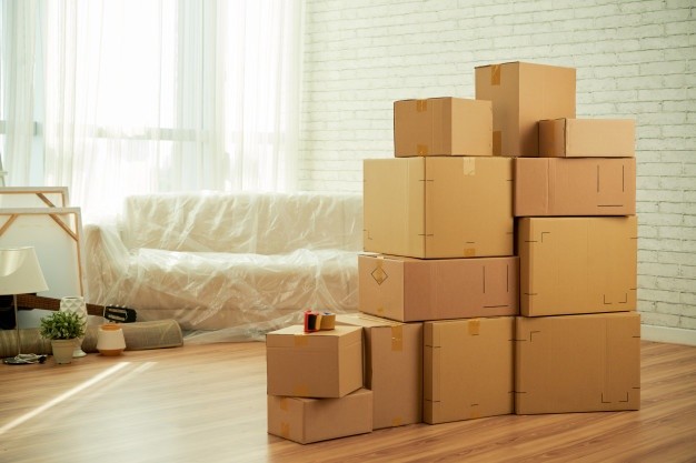 shot-room-interior-with-package-boxes-standing-middle-sofa-covered-with-film_1098-20802